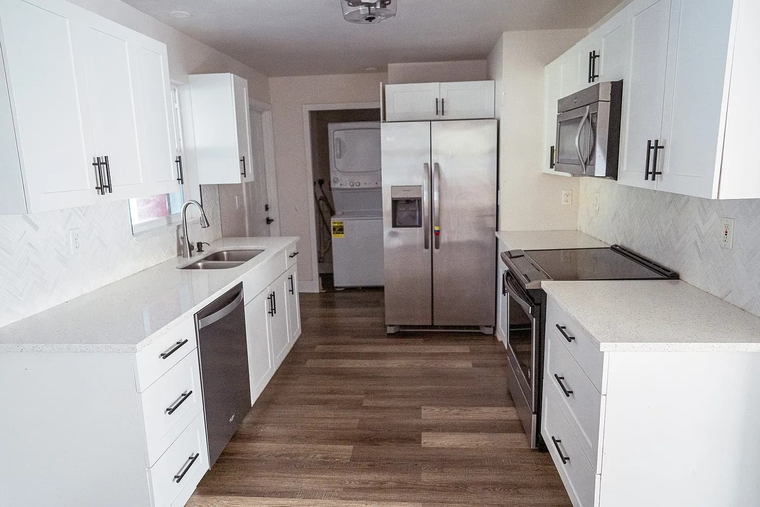 Full home remodel galley kitchen with quartz counters and shaker cabinetry by CFL Home Builders